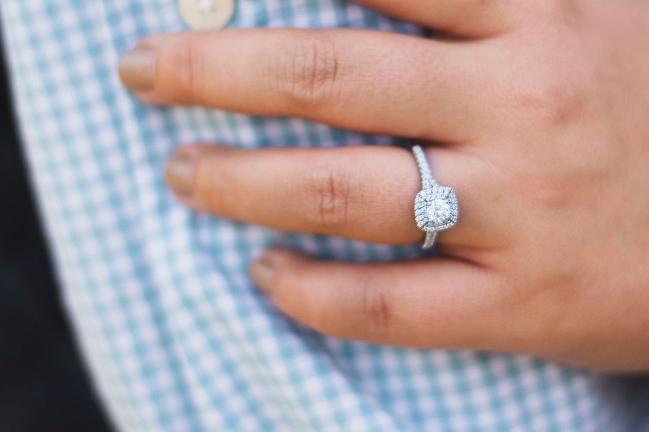 Fancy person wearing a brilliant halo engagement ring.