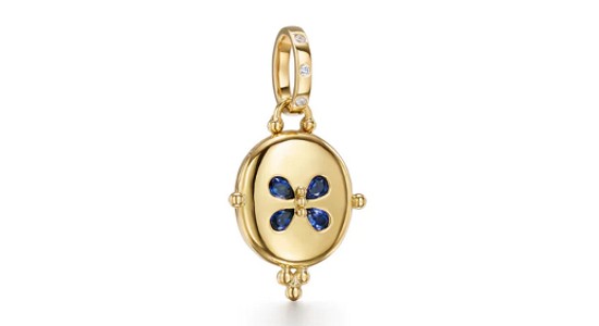 a yellow gold locket charm with sapphires in a butterfly shape