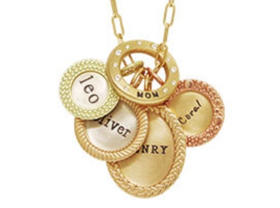 A collection of personalized pendants from Heather B. Moore on a gold chain with elongated links