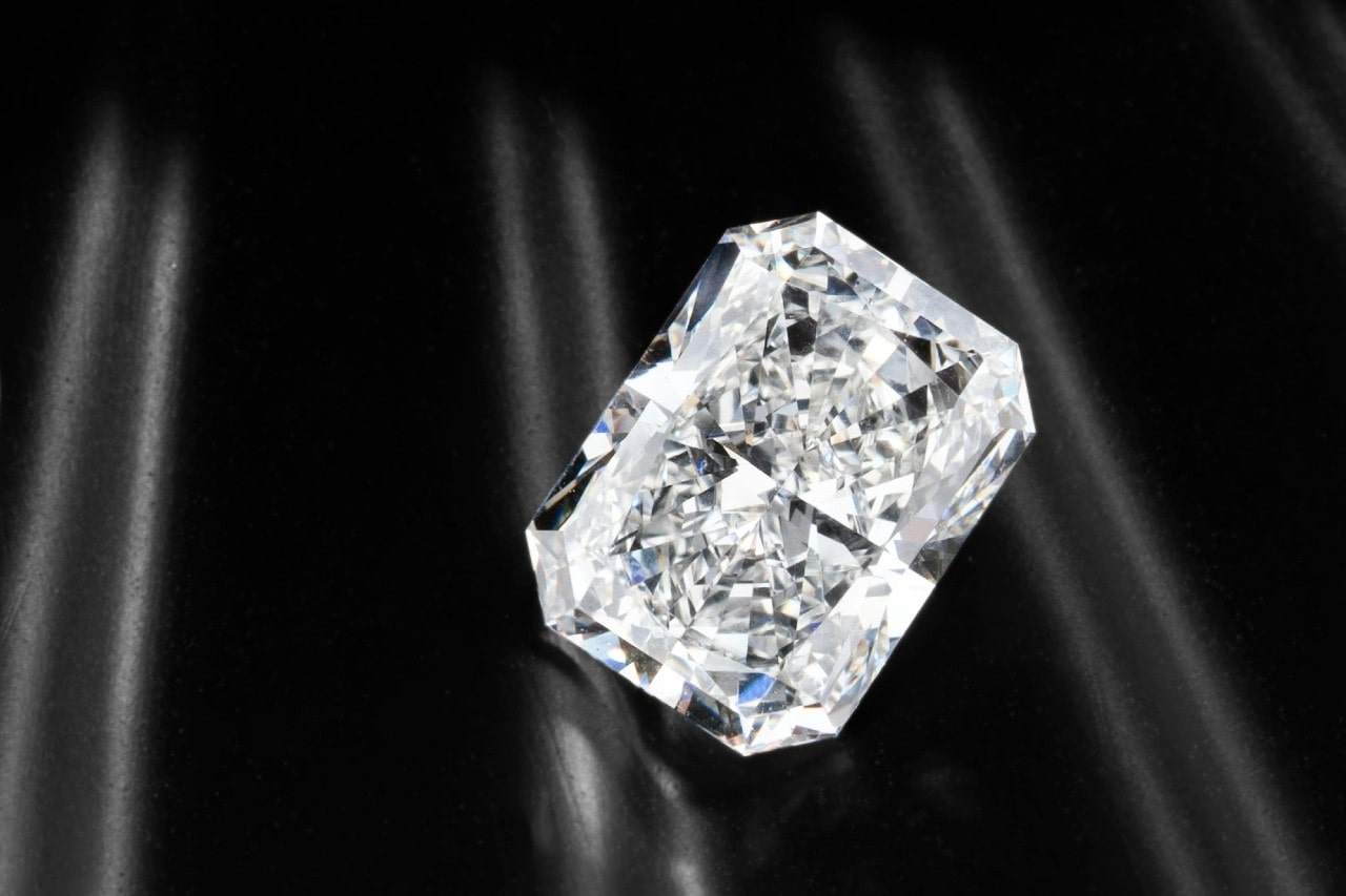 A close-up of a stunning lab grown diamond on a dark fabric backdrop.